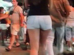 A hot brunette lady n the shortest pants ever smoking a cig