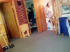 Chubby wife combing her hair in bathroom