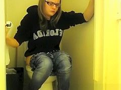 Girl in glasses pees in bathroom toilet
