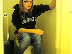 Girl in glasses pees in bathroom toilet