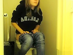 Girl in glasses pees in bathroom toilet