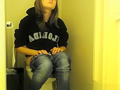 Girl in glasses pees in bathroom toilet