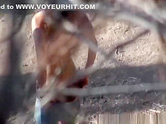 Girl in shorts and bikini peeing outdoors