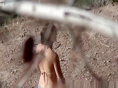 Girl in shorts and bikini peeing outdoors