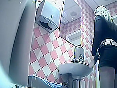 Girl in shorts pees in toilet