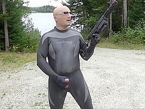 Wetsuited Silicone Masked Man On Patrol Near Lake