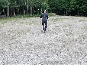 Wetsuited Silicone Masked Man On Patrol Near Lake
