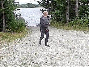 Wetsuited Silicone Masked Man On Patrol Near Lake