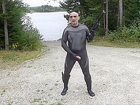 Wetsuited Silicone Masked Man On Patrol Near Lake