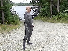 Wetsuited Silicone Masked Man On Patrol Near Lake