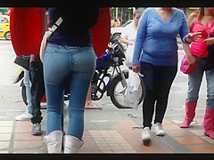 a beautiful round ass in jeans talking at a public phone