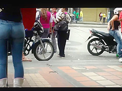 a beautiful round ass in jeans talking at a public phone