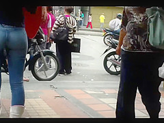 a beautiful round ass in jeans talking at a public phone