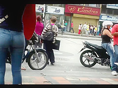 a beautiful round ass in jeans talking at a public phone