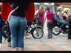 a beautiful round ass in jeans talking at a public phone