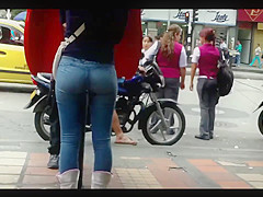 a beautiful round ass in jeans talking at a public phone