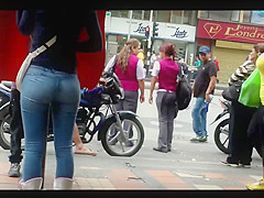 a beautiful round ass in jeans talking at a public phone