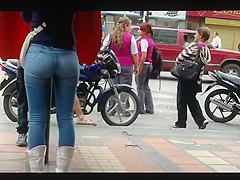 a beautiful round ass in jeans talking at a public phone