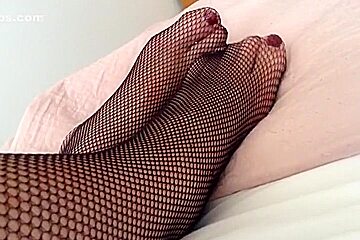 feet and legs in black fishnet tights
