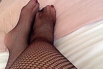 feet and legs in black fishnet tights